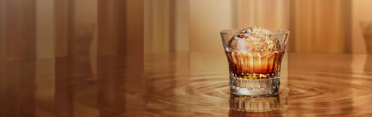 suntory whisky in old fashioned glass with large round ice in gold room